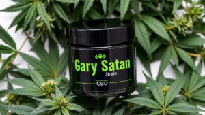 A black plastic jar having Gary Satan Strain in it and there are cannabis leaves around.